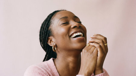 Close up portrait of a young African American woman smiling and laughingの素材