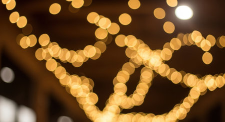 A captivating abstract background featuring numerous blurred golden bokeh lights, creating a warm, festive, and inviting atmosphere. The soft focus highlights the glowing circles, perfect for holiday or celebratory designs.の素材