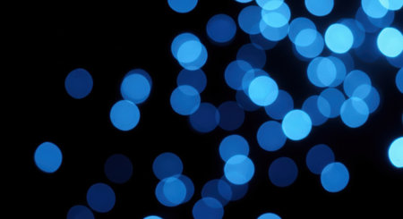 Soft, out-of-focus blue circles of light create a dreamy, bokeh effect against a dark background.の素材