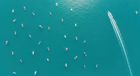 An aerial perspective captures a speed boat leaving a distinct white wake on the vibrant turquoise ocean, with numerous small white buoys scattered across the waters surface.の素材
