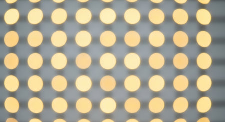A grid of golden circles creates an abstract pattern, offering a modern and geometric visual texture. The arrangement is uniform and visually appealing.の素材