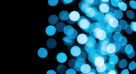 A mesmerizing display of out-of-focus blue lights against a stark black backdrop, creating a soft, dreamy, and abstract visual experience.の素材