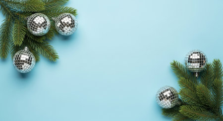 Festive holiday background with evergreen fir branches adorned with shiny silver disco ball ornaments, creating a joyful and celebratory atmosphere for Christmas and New Year.の素材