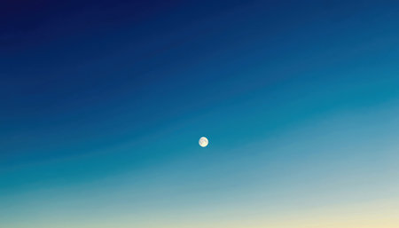 A luminous full moon is visible in the vast expanse of a clear blue sky, with a subtle gradient of color.の素材