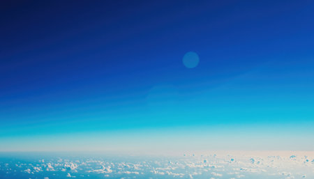 A breathtaking view from above the clouds, showcasing the gradient of the blue sky and a faint moon.の素材