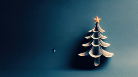 A beautifully crafted Christmas tree ornament with a golden star on top, set against a deep blue backdrop, creating a festive and sophisticated feel.の素材