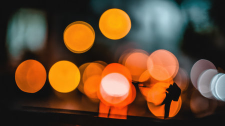Abstract background of glowing orange and white bokeh lights, creating a dreamy and atmospheric effect.の素材