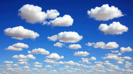 A beautiful expanse of clear blue sky filled with numerous fluffy white cumulus clouds, creating a serene and picturesque natural scene.の素材