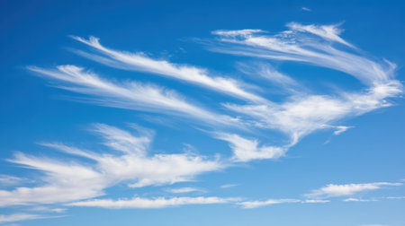 Delicate, feathery cirrus clouds stretch across a clear, vibrant blue sky, creating an ethereal and serene atmosphere.の素材