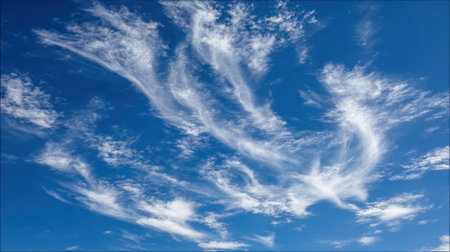 Beautiful wispy cirrus clouds form intricate patterns against a clear, bright blue sky, creating a sense of depth and movement.の素材
