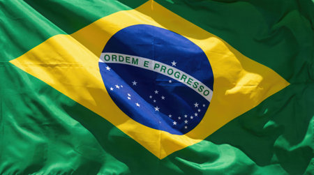 a vibrant close up of the brazilian flag, showcasing its green, yellow, and blue colors, along with the motto of order and progress in detail.の素材