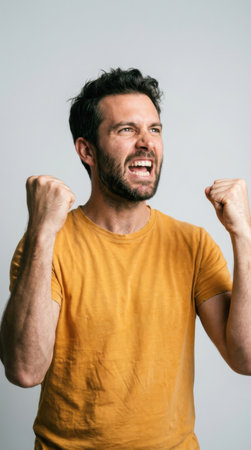 Portrait of a happy young man celebrating success isolated on a gray backgroundの素材