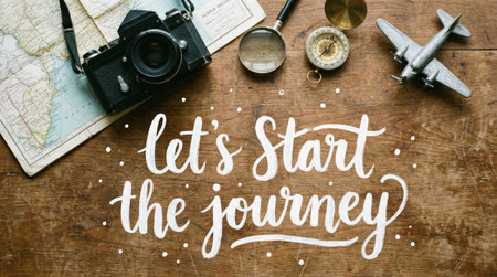 A captivating overhead shot showcasing travel essentials on a rustic wooden surface. The composition includes a vintage camera, a detailed map, a compass, a magnifying glass, and a miniature airplane, all arranged to evoke a sense of adventure and exploration. The phrase Lets Start the Journey is artfully displayed.の素材