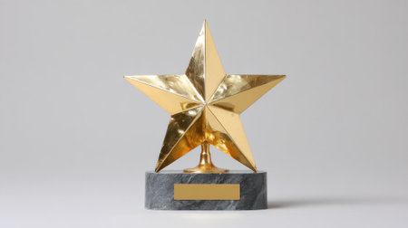 A gleaming golden star trophy stands proudly on a dark marble base, ready for an award.の素材
