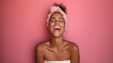 A vibrant portrait of a young woman with a radiant smile, her eyes closed in pure joy, wearing a pink headband against a solid pink background.の素材