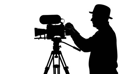 A black silhouette of a person wearing a hat, meticulously adjusting a professional video camera...