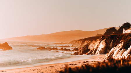 A tranquil seascape view of a beautiful sandy beach and rocky cliffs bathed in the warm, soft light of a setting sun. Gentle waves roll onto the shore.の素材