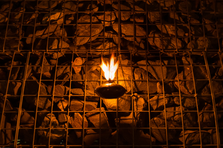 Burning oil lamp and rock wall.の写真素材