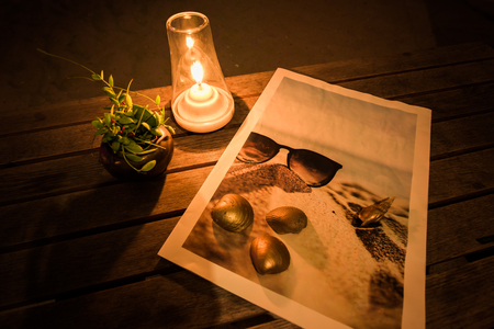 Candle ,Dave plant ,Golden shell and sea picture on the table at romantic night.の写真素材