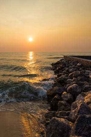 Sunrise over sea and stone coast.の写真素材