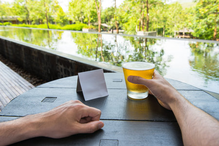 Relax time with glass of beer at natural resort.