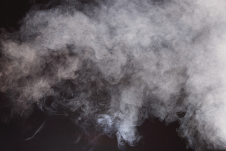 Dense Fluffy Puffs of White Smoke and Fog on Black Background, Abstract Smoke Clouds, All Movement Blurred, intention out of focus, and high low exposure contrast, copy space for text logoの写真素材