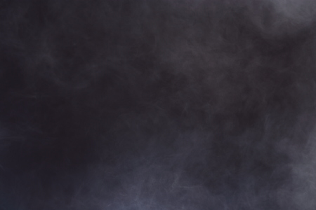 Dense Fluffy Puffs of White Smoke and Fog on Black Background, Abstract Smoke Clouds, All Movement Blurred, intention out of focus, and high low exposure contrast, copy space for text logoの写真素材