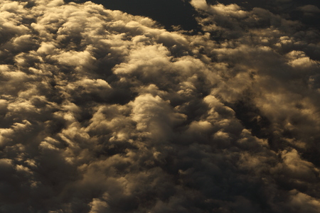 Sunset reflect Dense Fluffy Puffs of White Clouds red sky at high level attitude, view from window airplane so Unsharp and Noise, copy spaceの写真素材