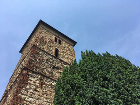 View Of Top Of Church Next To Green Treeの写真素材