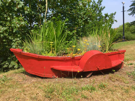 Small Red Boat Used As Flower Bed For Various Plantsの写真素材