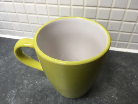 Closeup Of Green Mug Against White Tileの写真素材
