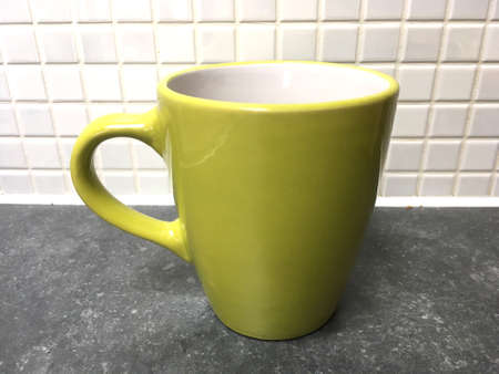 Green Mug Against White Tiled Wallの写真素材