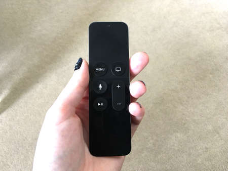Hand Holding Black Smart Remote Controlの写真素材