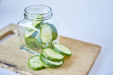 Cucumber sliced pickle in bottle on white backgroundの写真素材