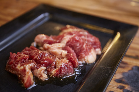 Chopped raw chuck beef on black plateの写真素材