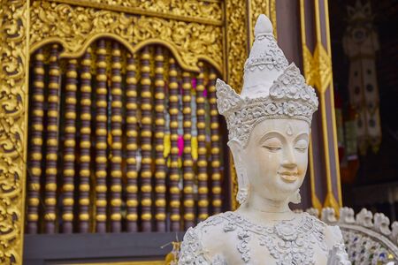 White Buddha statue with golden backgroundの写真素材