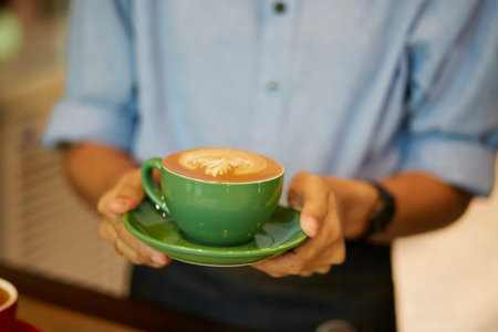 Serving cup of coffee in handの写真素材