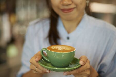 Serving cup of coffee in handの写真素材