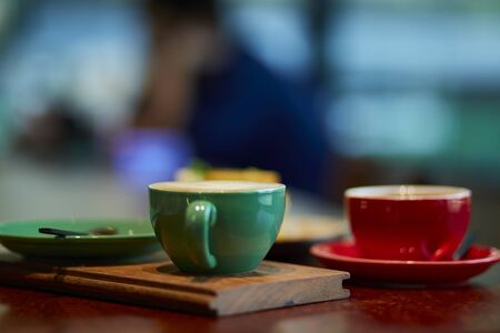 Colorful cup of coffee on wooden tableの写真素材