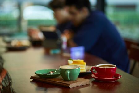 Colorful cup of coffee on wooden tableの写真素材