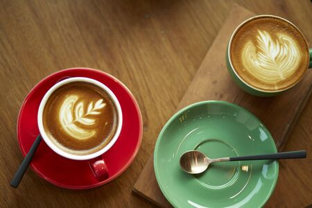 Top view of colorful cup of coffee on wooden tableの写真素材