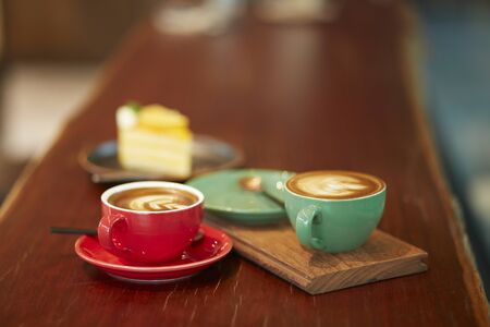 Colorful cup of coffee on wooden tableの写真素材