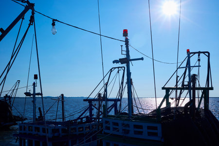 Silhouette fishing boat with sunny sky