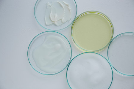 Cosmetics cream, foam and essential oil in petri dish