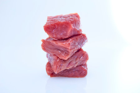 Cube raw beef sliced on white backgroundの写真素材