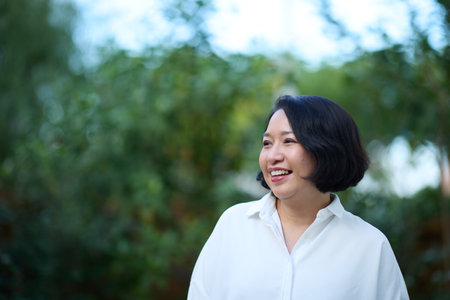 Portrait of a happy senior Asian woman in the parkの写真素材