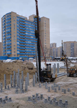 Koper installs piles on construction site. pile driving equipmenのeditorial素材