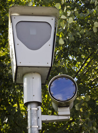 A traffic camera with a green tree background の写真素材