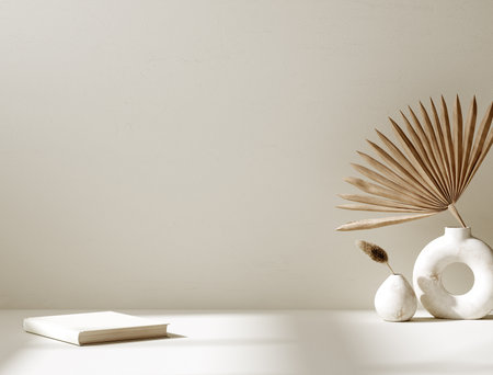 Minimalist still life with palm leaf, vase and notebook on white backgroundの写真素材