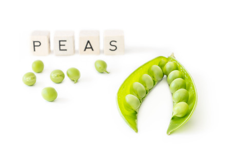 Green peas isolated on white background with letters. Healthy food vegetableの写真素材